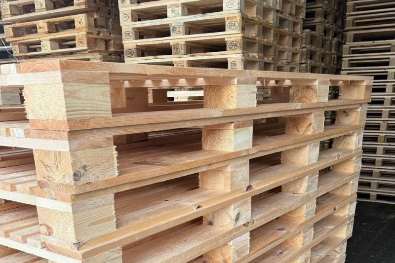 Stosy nowych, drewnianych palet Euro (EPAL) ułożone w magazynie producenta w Trzebini.