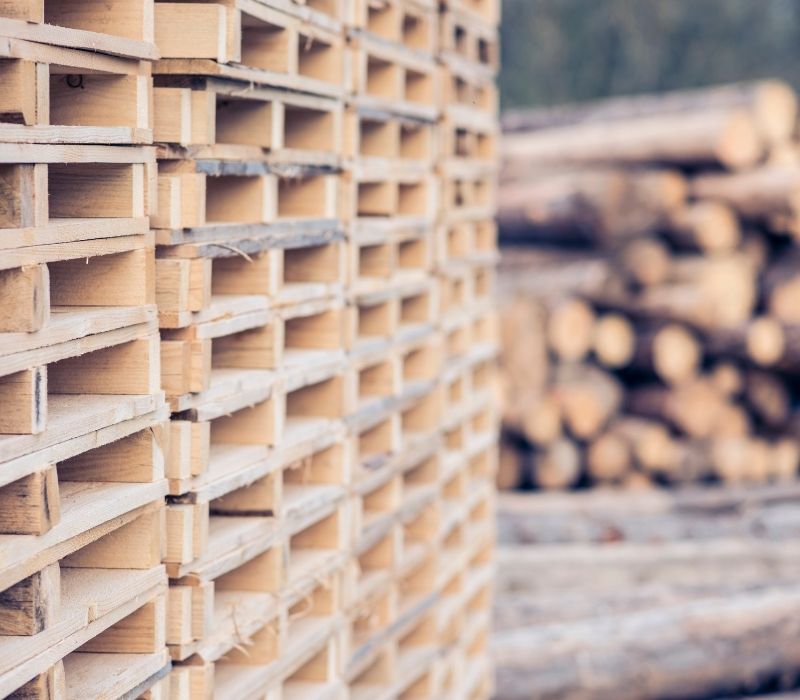 Kompleksowa obsługa palet: od kłód drewna po gotowe palety drewniane składowane w stosach