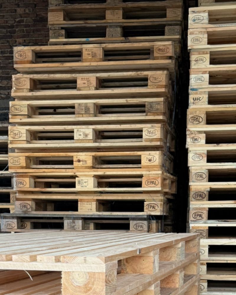 Magazyn z wysokimi stosami certyfikowanych palet EPAL i palet przemysłowych gotowych do wysyłki.