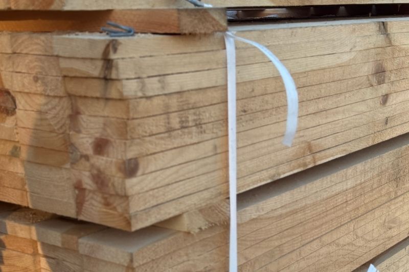 Zbliżenie na kwadratowe wsporniki (klocki) do palet wykonane z prasowanych wiórów drzewnych z widocznym otworem montażowym, ułożone jeden na drugim.